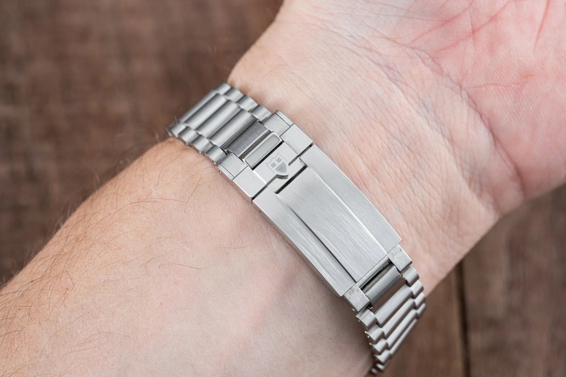 Stainless steel watch bracelet with solid links worn on wrist, showing brushed finishing and adjustable clasp system for Tudor Black Bay 58 GMT