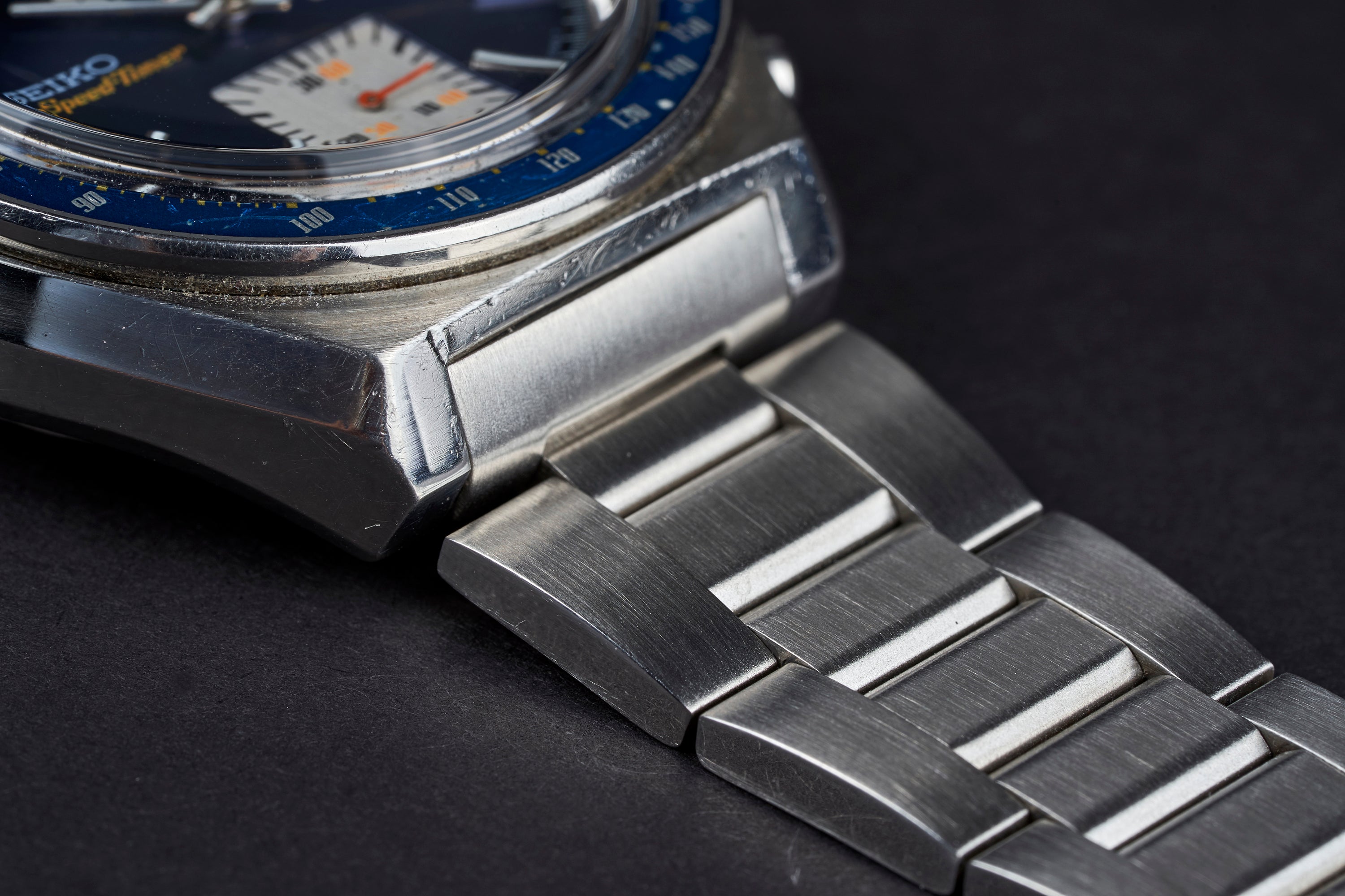 Vintage Seiko 6138 chronograph watch with blue bezel and tapered stainless steel bracelet detail