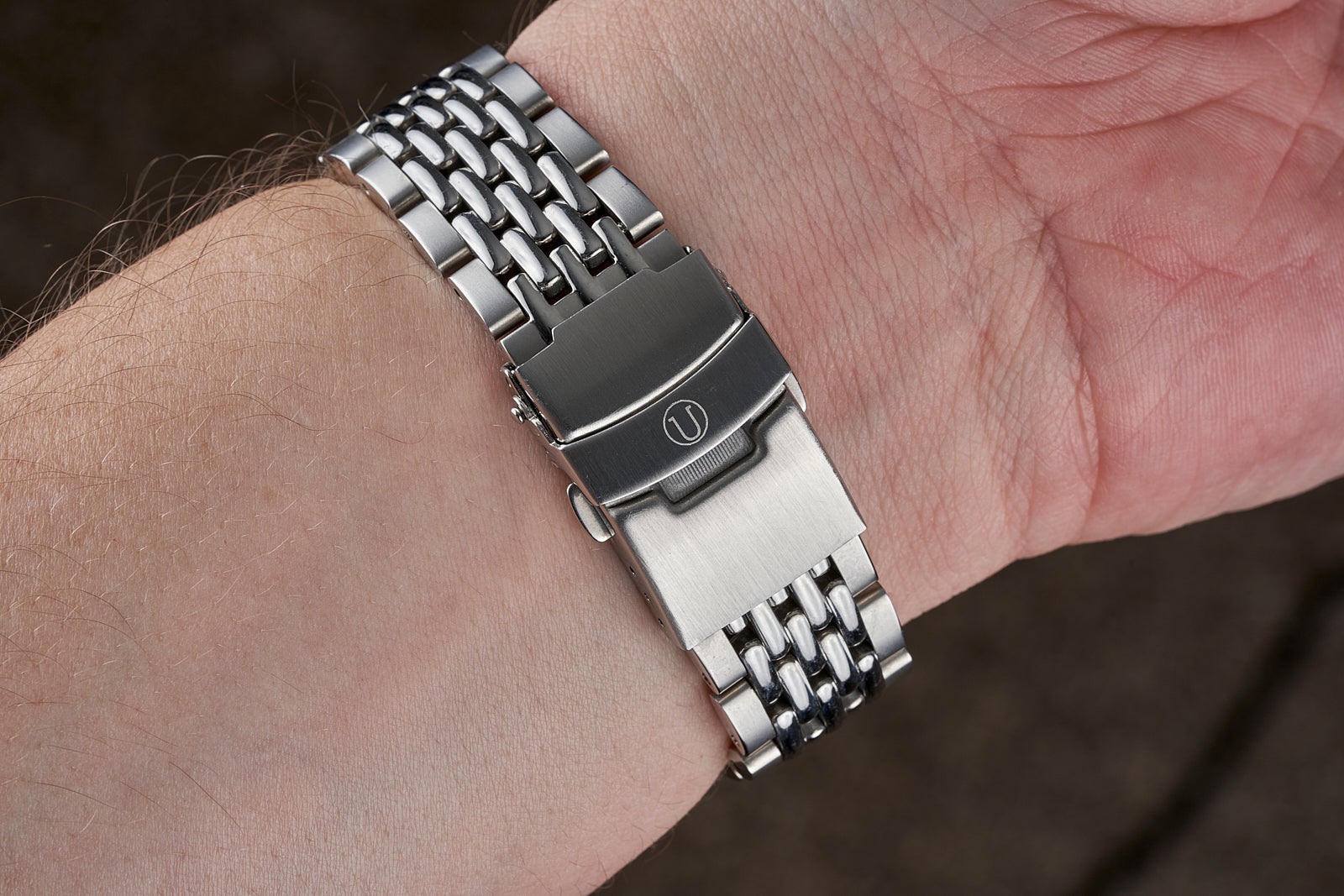 Stainless steel beads of rice metal watch bracelet on wrist with fold-over clasp and integrated links
