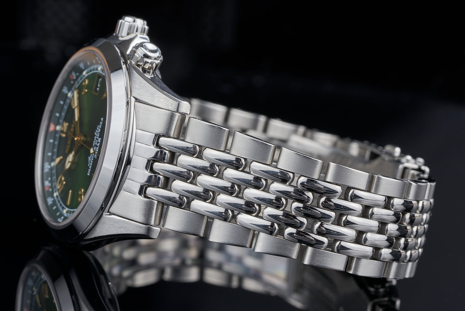 Seiko SARB017 alpaca watch with stainless steel beads of rice bracelet, green dial, and chronograph subdials on black background