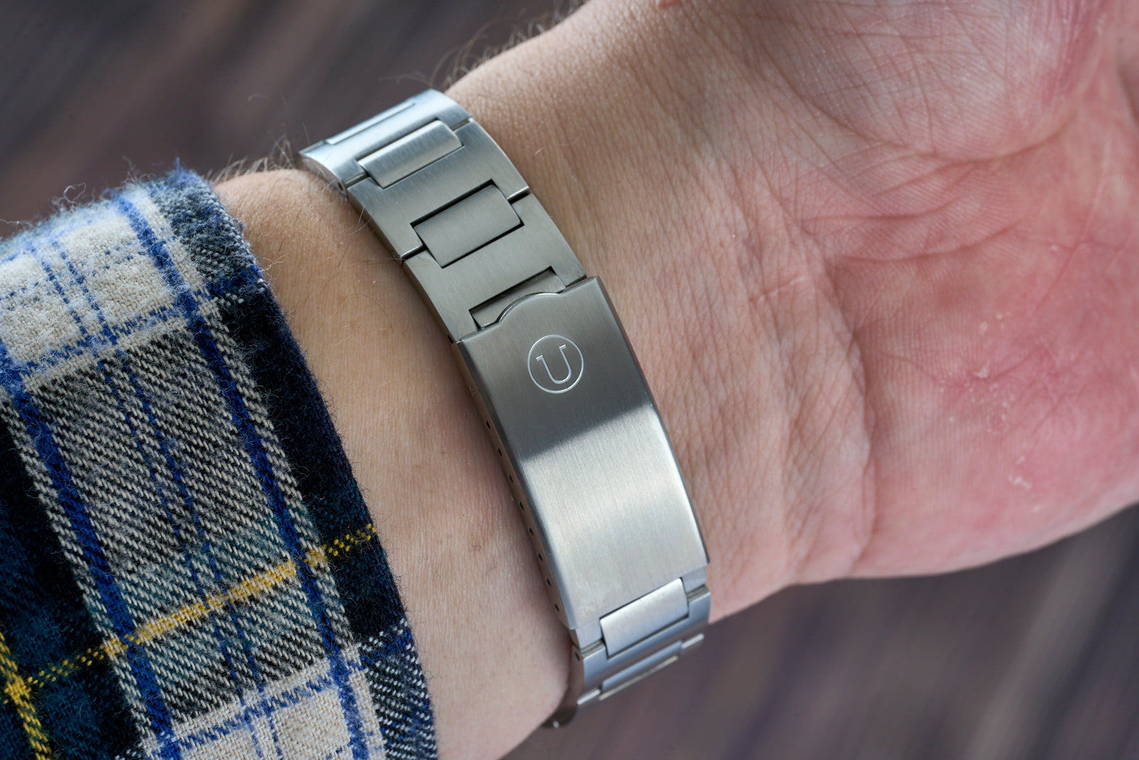 Stainless steel H-Link bracelet on wrist with engraved logo, compatible with Seiko 6105 dive watch