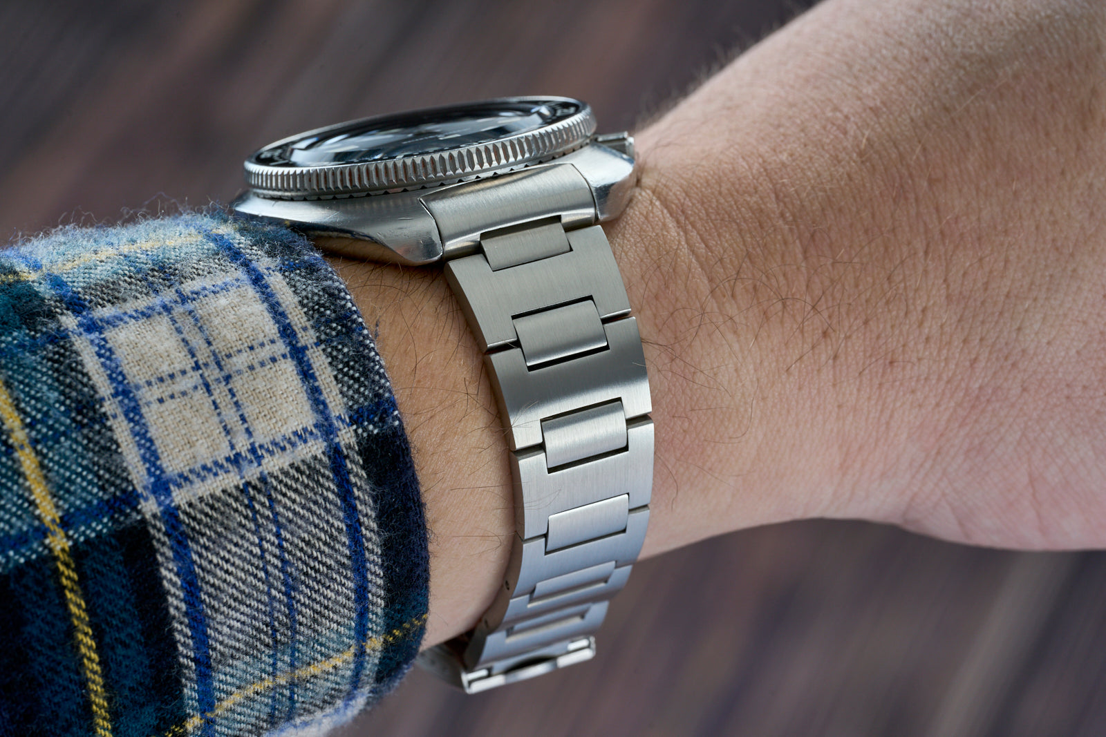 Stainless steel H-Link bracelet for Seiko 6105 dive watch on wrist with plaid shirt