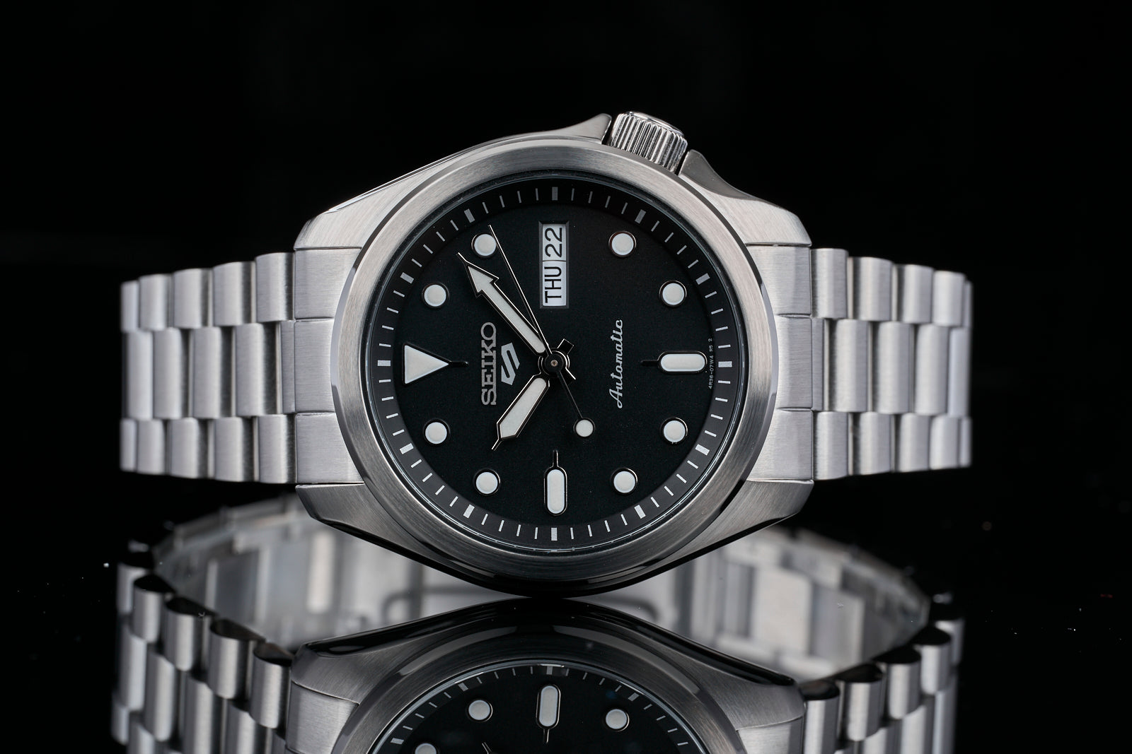 Seiko 5 Sports automatic watch with stainless steel bracelet, black dial, day-date window, and luminous hands