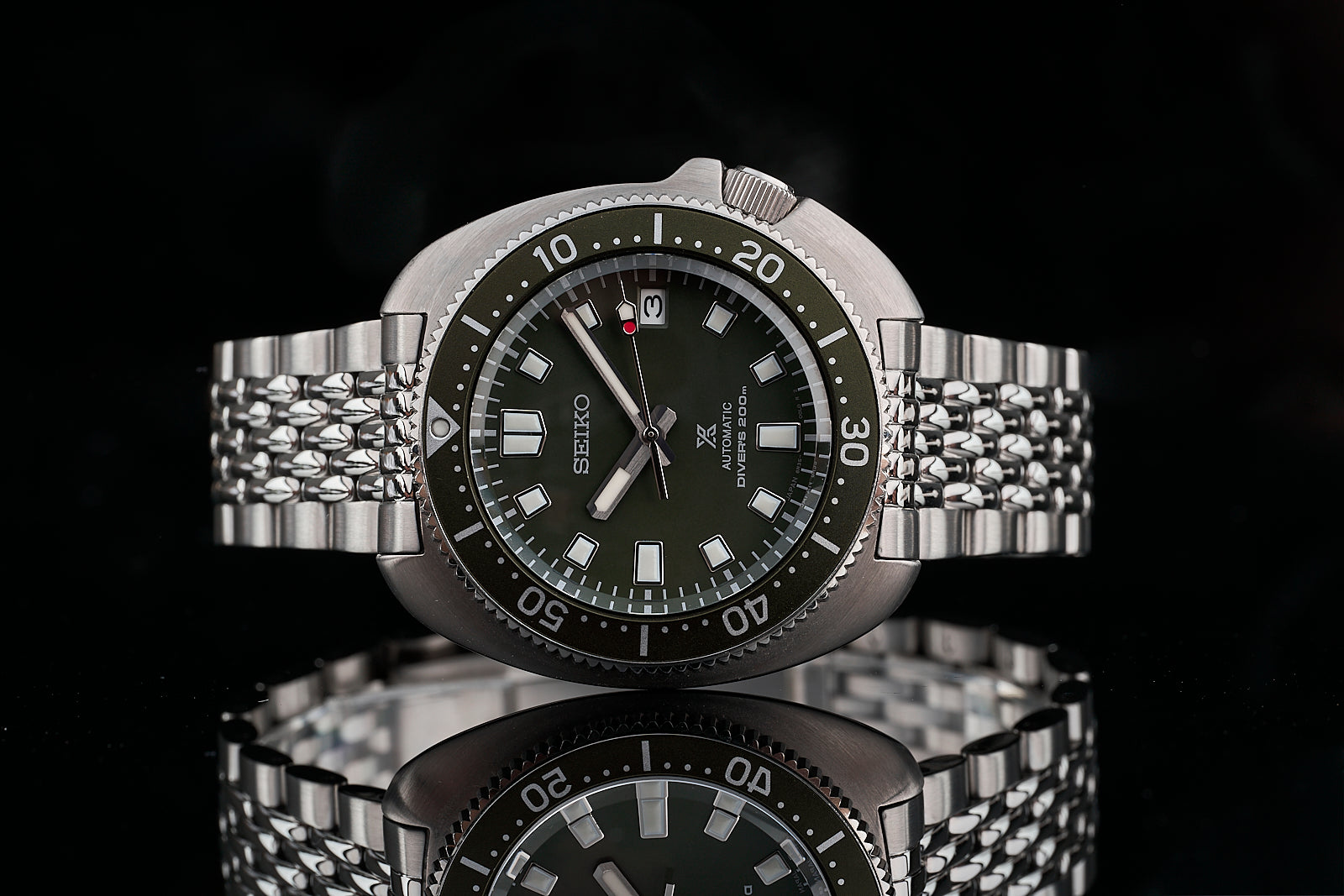 Seiko SPB15x Willard automatic diver watch with dark green dial, stainless steel beads of rice bracelet, and rotating bezel
