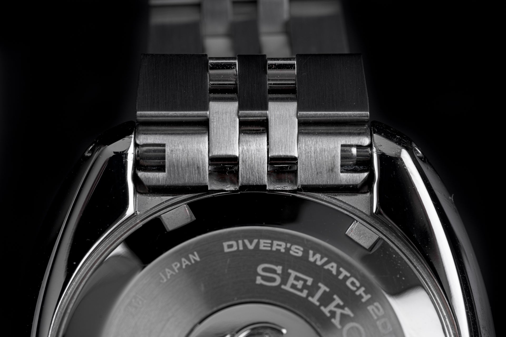 Stainless steel diver's watch bracelet with solid link construction and brushed finish, close-up detail shot