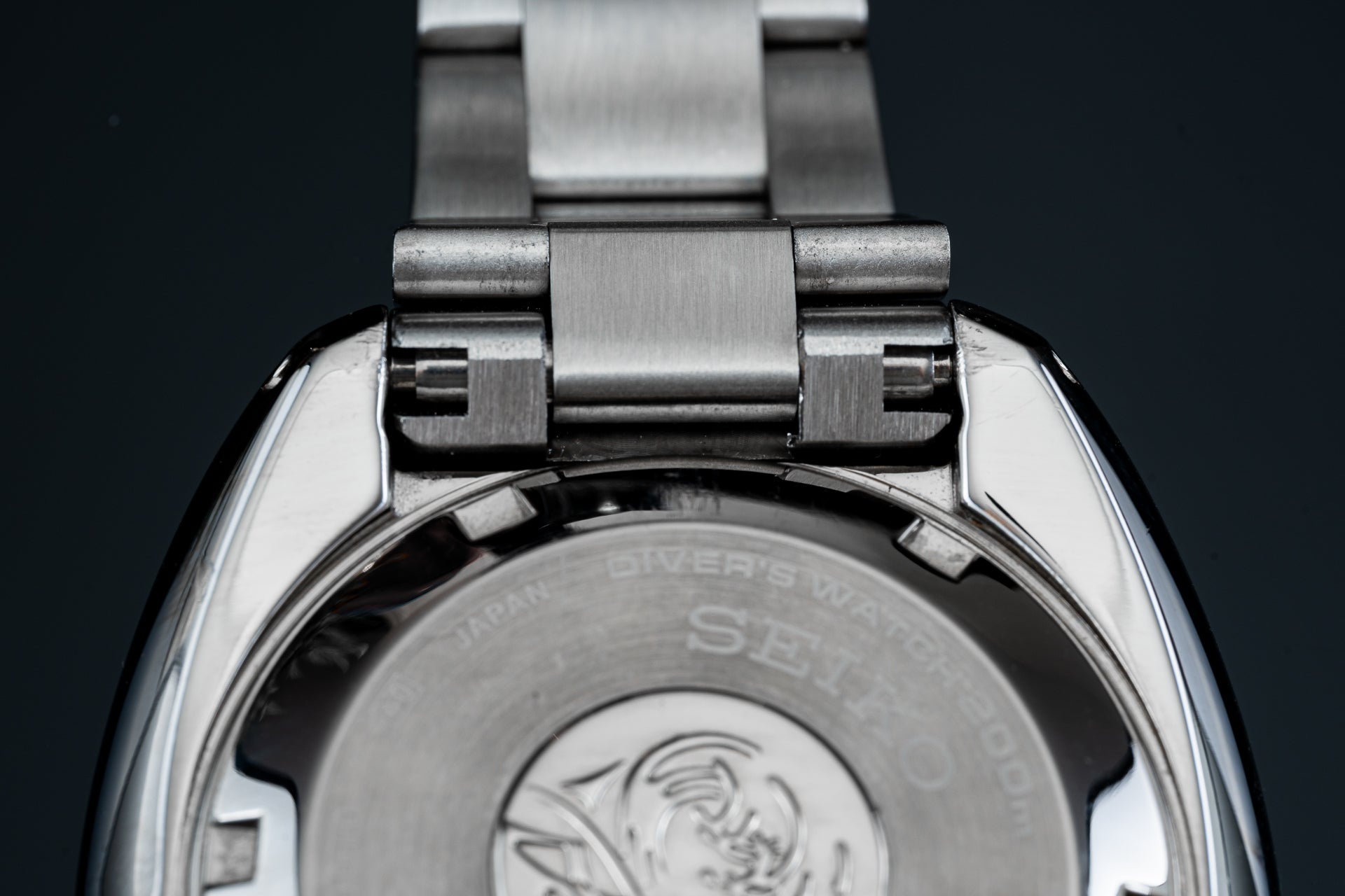 Seiko SPB15x Willard dive watch with stainless steel bracelet and screw-down caseback, overhead view on dark background