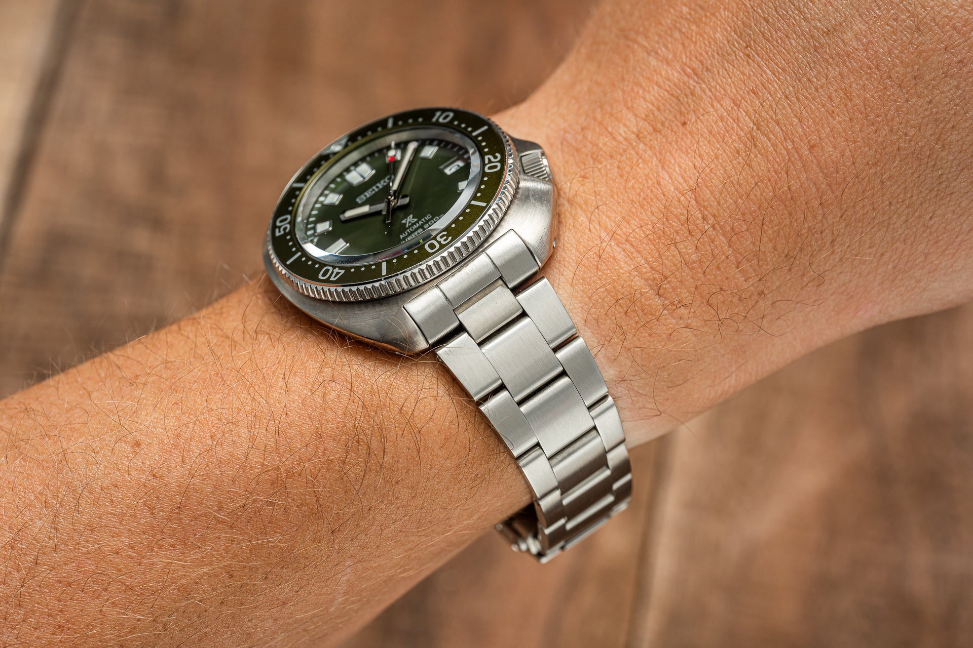 Seiko SPB15x Willard dive watch with green dial and stainless steel bracelet worn on wrist