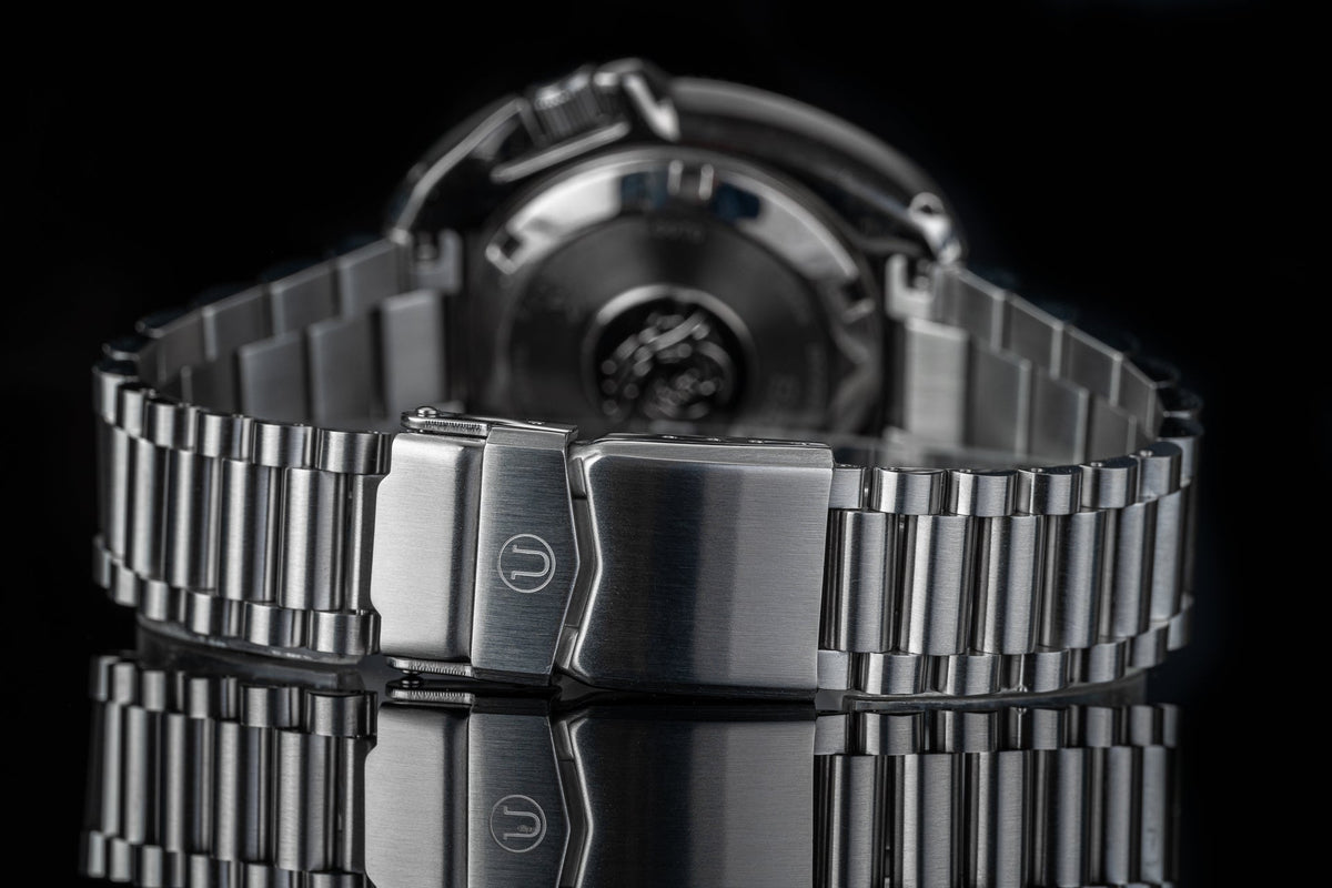 Stainless steel dive watch with matching metal bracelet and fold-over clasp, displayed front view against black background