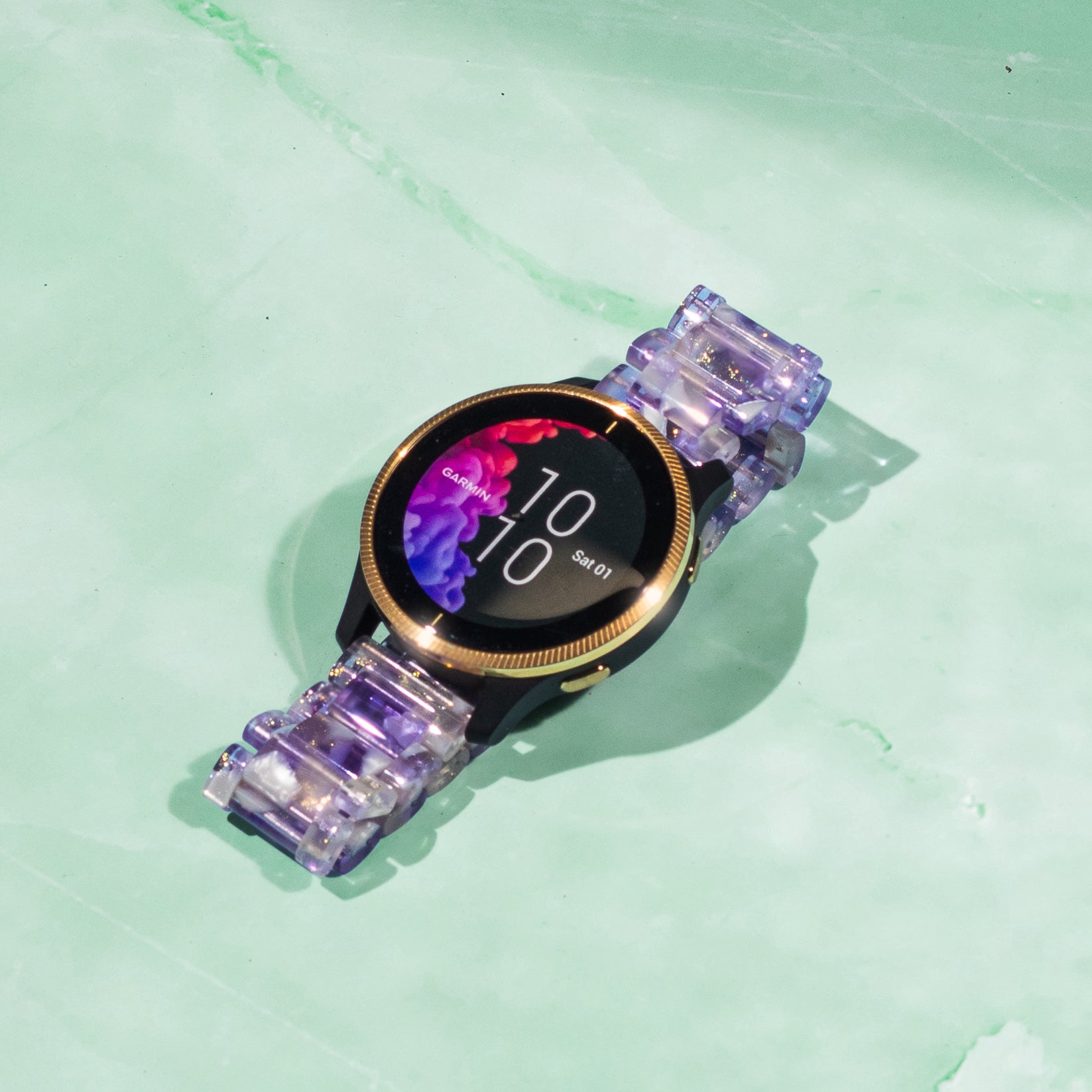 Purple translucent crystal acetate smartwatch band with quick release connector on mint green background