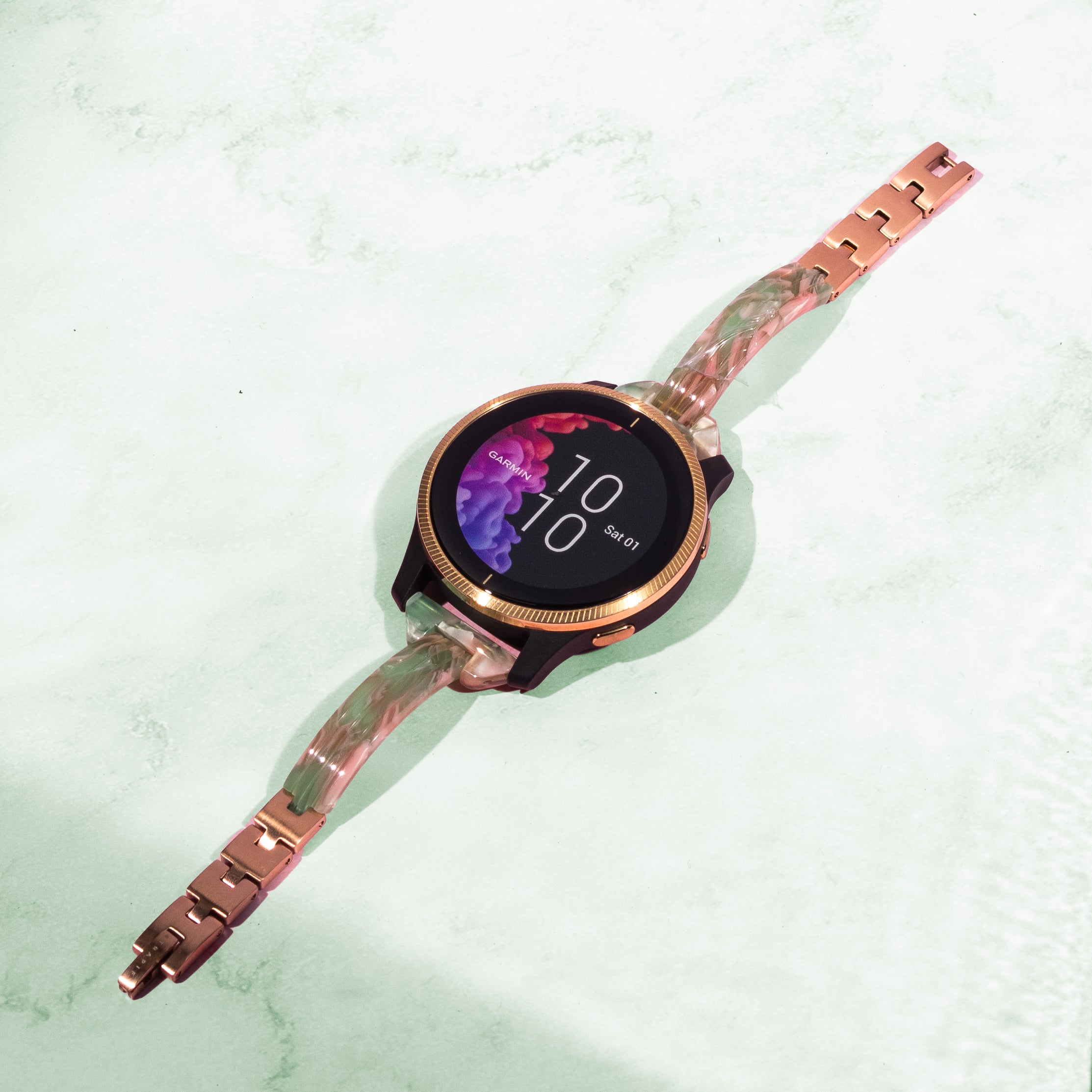 Rose gold smartwatch with jade pearl acetate quick-release bangle strap and round AMOLED display showing time 10:10