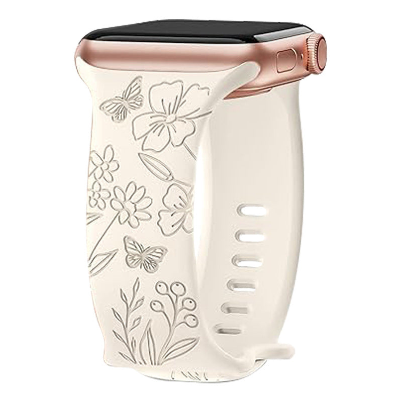 Cream silicone Apple Watch band with rose gold connector featuring engraved floral and butterfly design