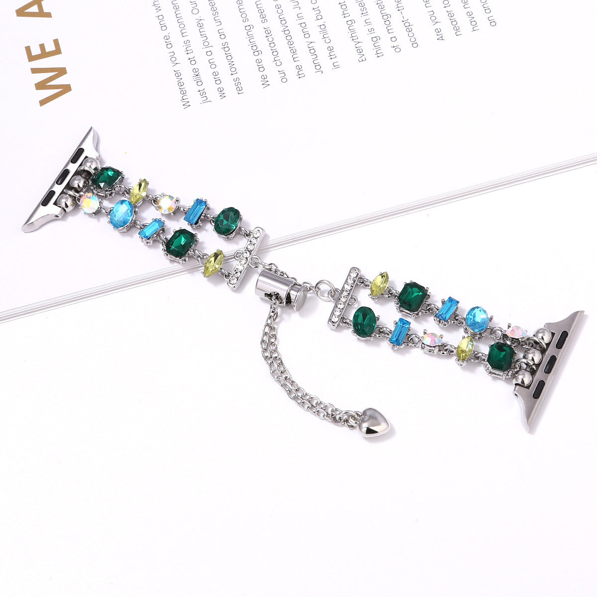 Multicolored crystal beaded Apple Watch band with emerald green, blue, and yellow gemstone charms on silver connector