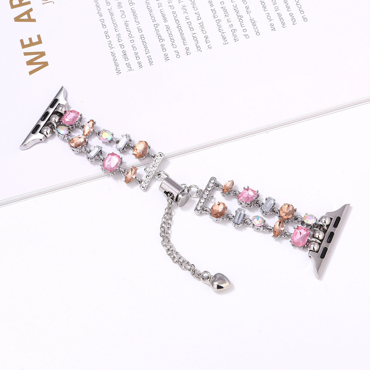Crystal beaded smartwatch band with pink and champagne gems, silver metal connectors, and heart charm for Apple Watch