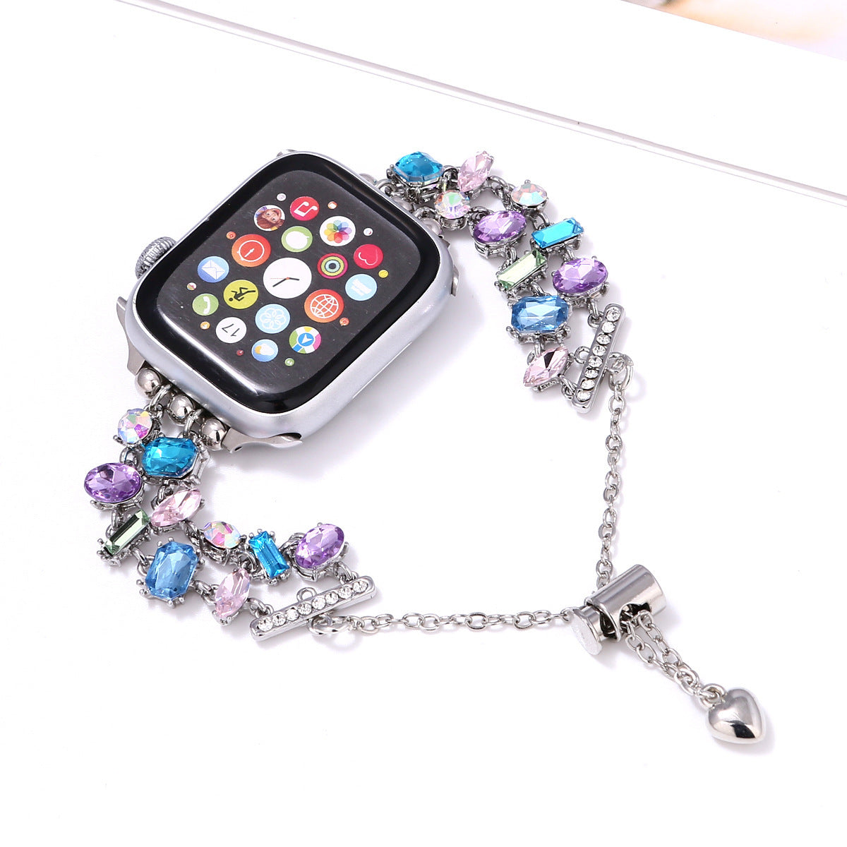 Silver smartwatch with colorful crystal gemstone bracelet strap in purple, blue and pink tones with heart charm pendant