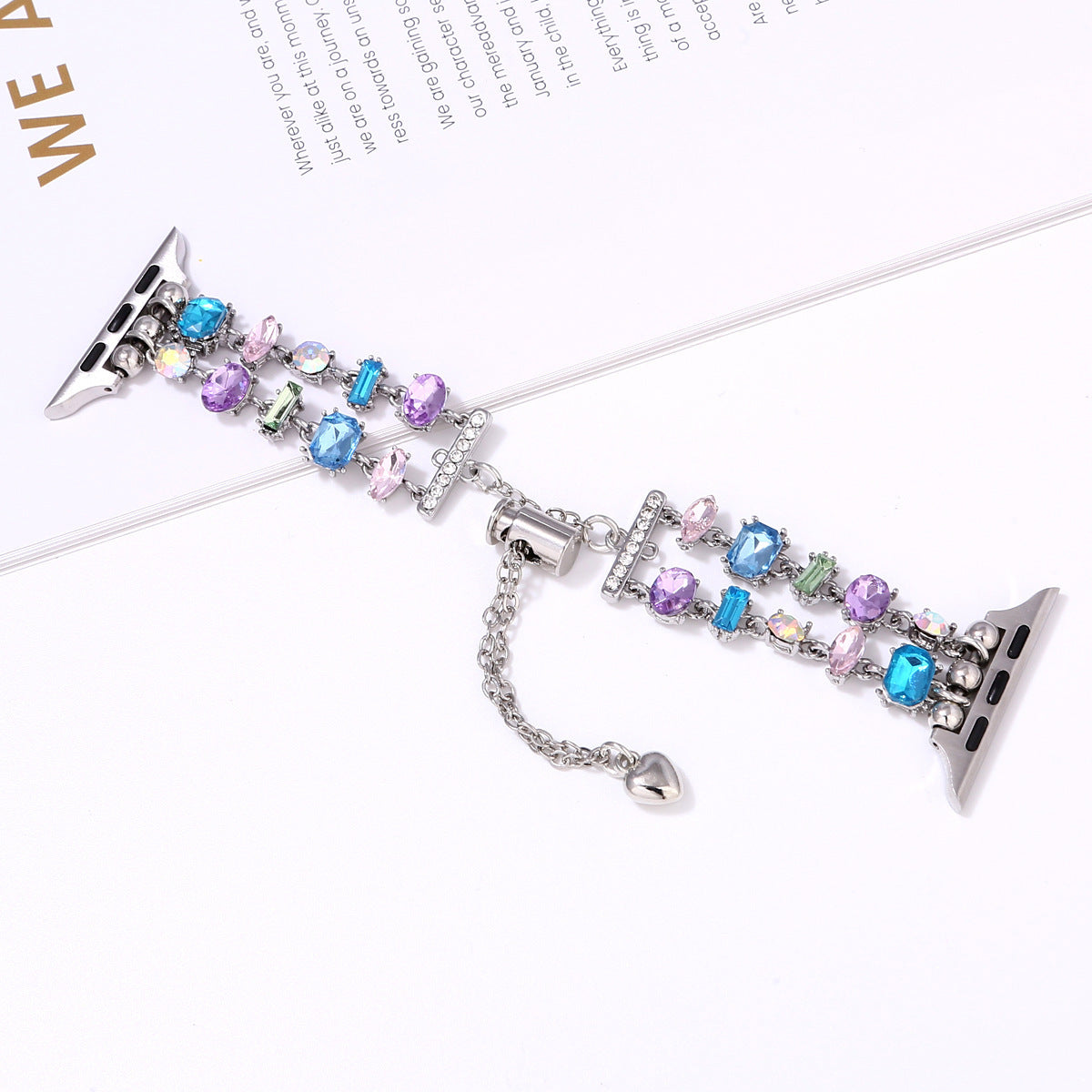 Crystal beaded Apple Watch band with multicolored gemstones in blue, purple and pink tones, silver connector hardware and heart charm