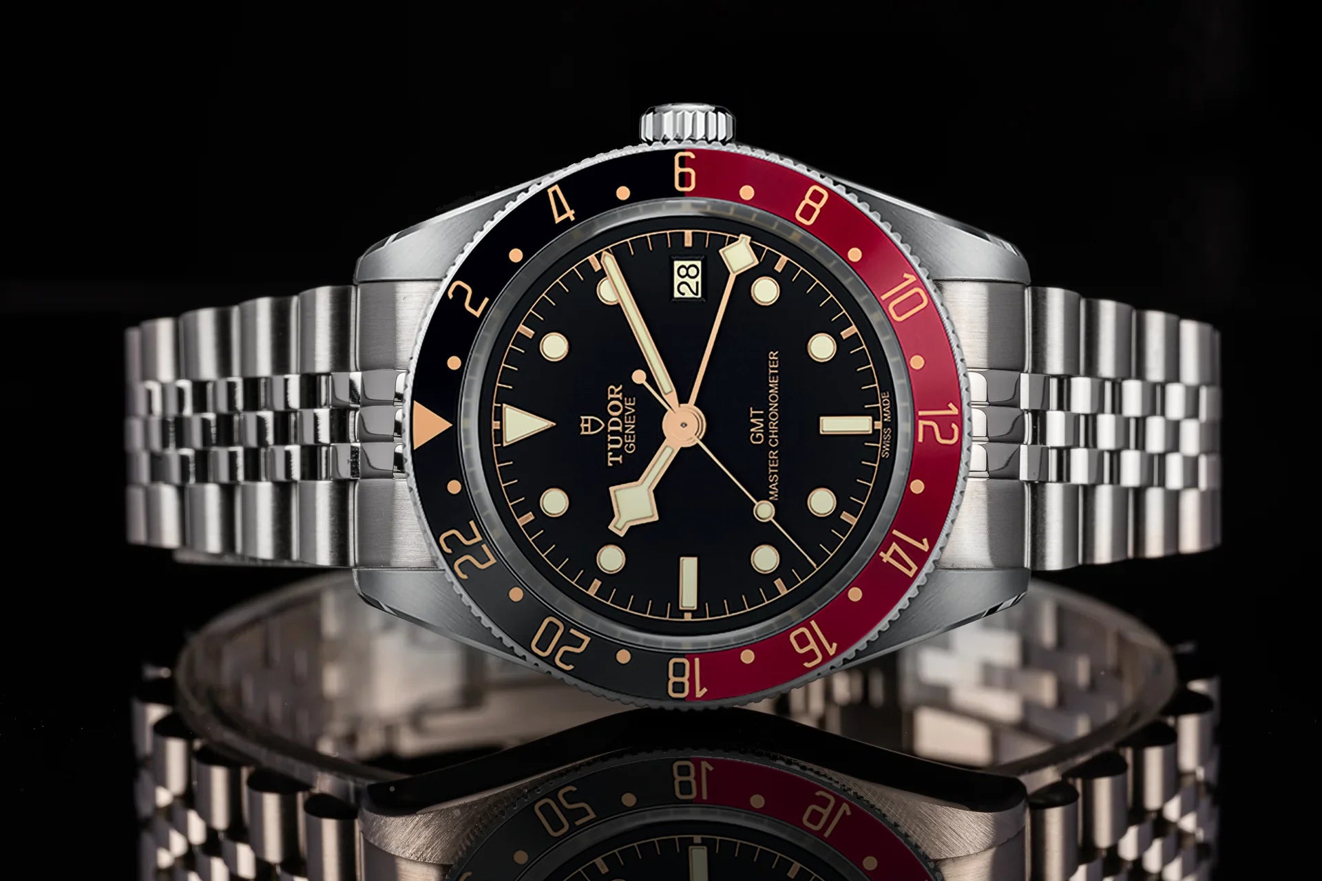 Tudor Black Bay 58 GMT stainless steel dive watch with black dial, red and black bezel, and matching metal bracelet
