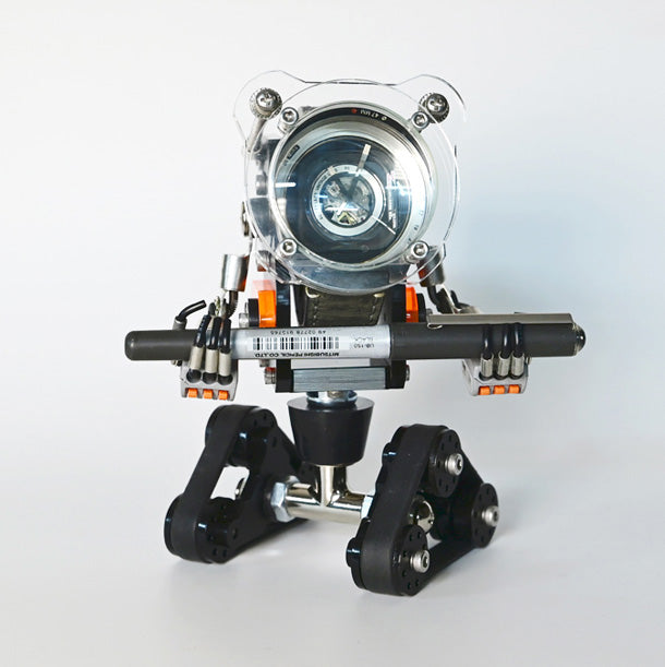 Transparent RoboTank watch stand with black base, articulated limbs, and orange accents holding timepiece upright