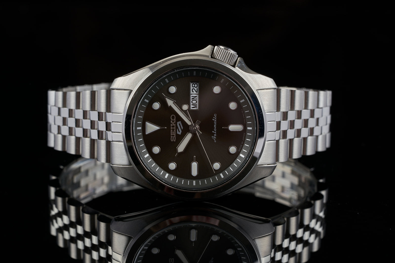 Seiko 5 automatic watch with black dial, stainless steel jubilee bracelet, and day-date window on silver metal band