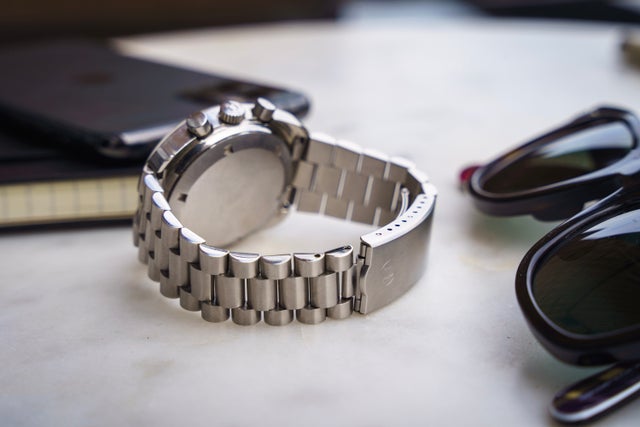Stainless steel link bracelet for Omega Seamaster 176.007 watch, displayed on white surface with accessories