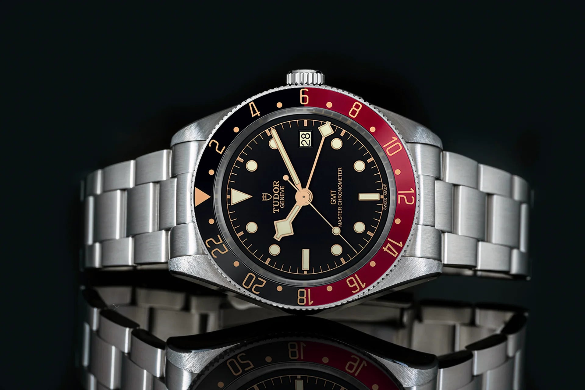 Tudor Black Bay 58 GMT stainless steel watch with black dial, red and black bezel, bracelet, and cream-colored hands