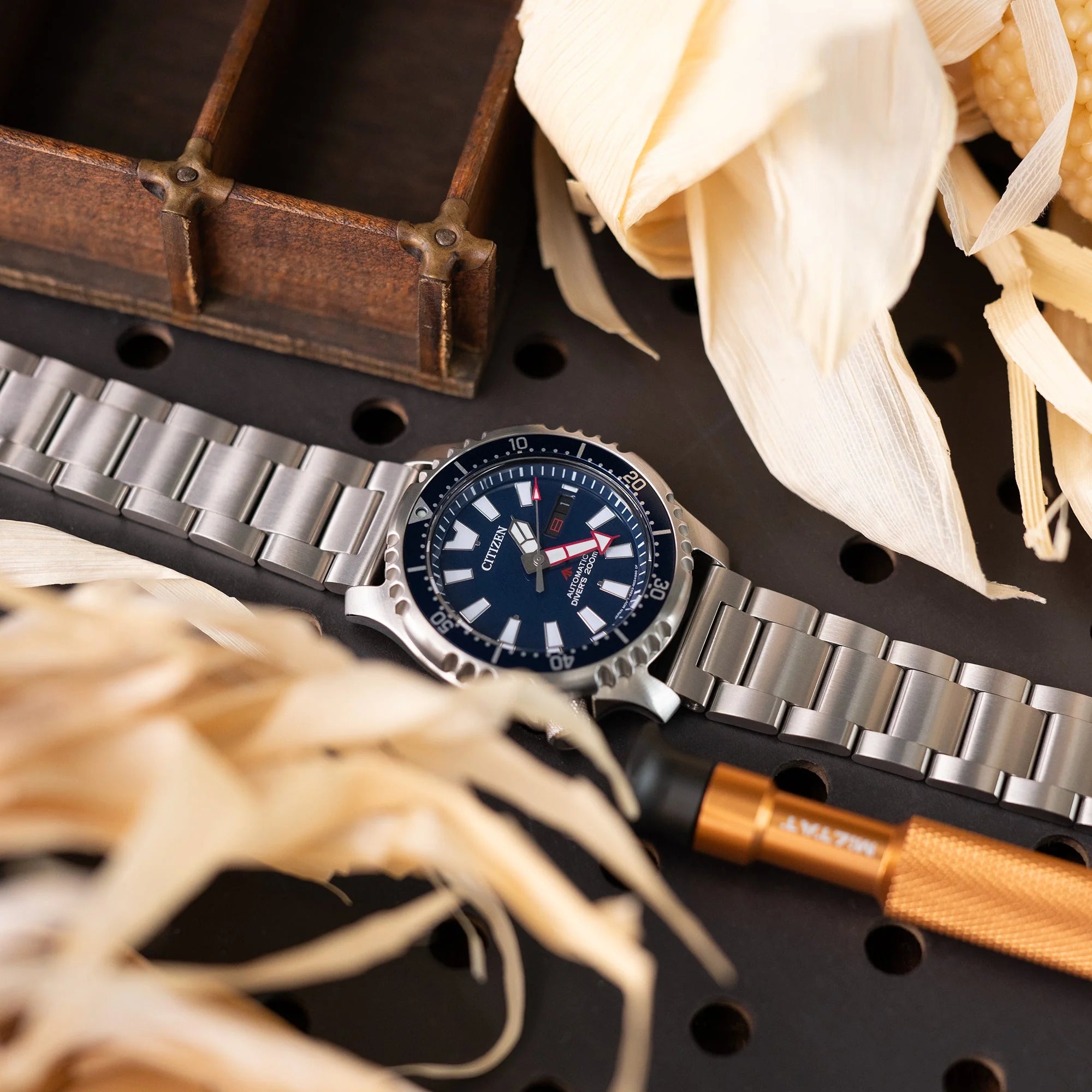 Strapcode titanium Super-O2 quick release bracelet with pull-twist mechanism on dive watch, styled with leather and natural elements