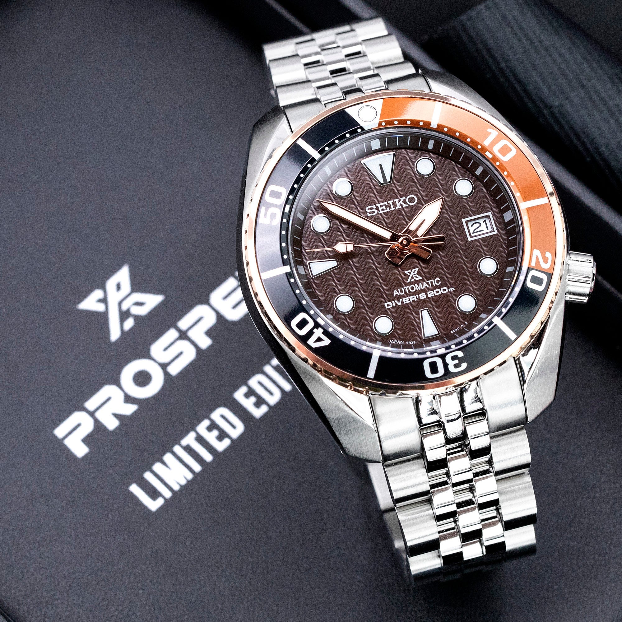 Seiko Prospex automatic dive watch with orange and black bezel, brown dial, stainless steel bracelet on display box