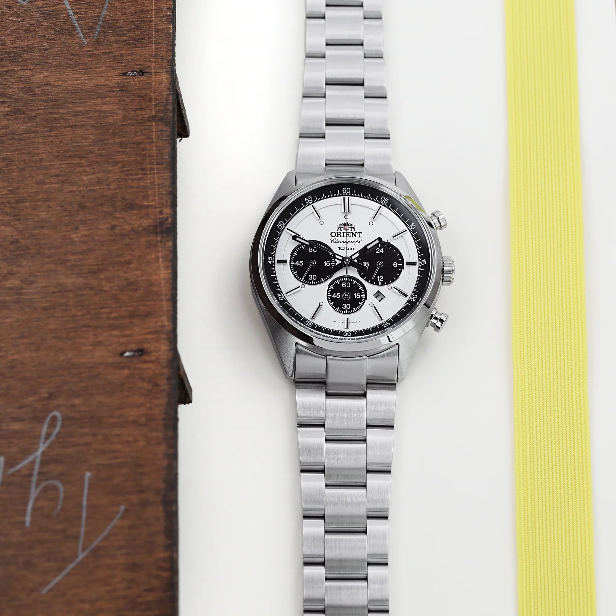 Silver stainless steel chronograph watch with white dial and black subdials on matching metal bracelet