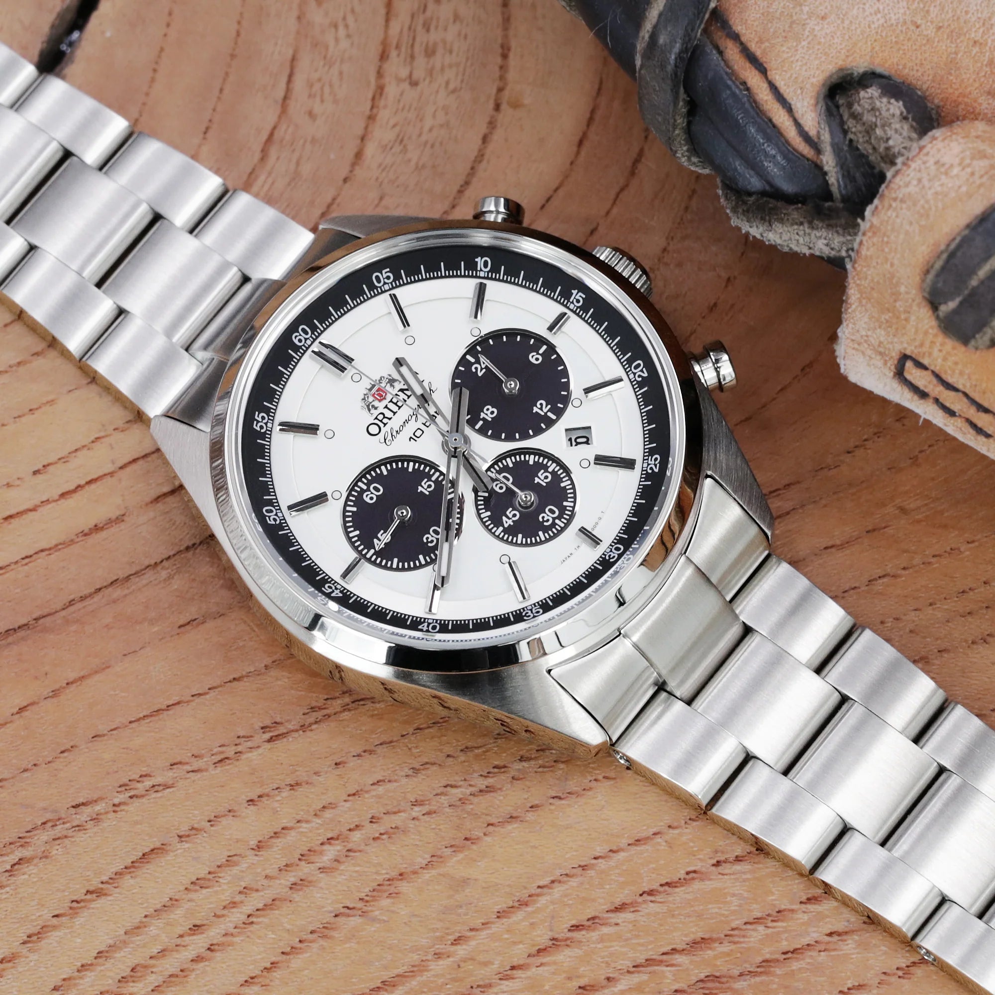 Strapcode Super-O Boyer stainless steel bracelet on Orient Mako II chronograph watch with white dial and black subdials on wooden surface