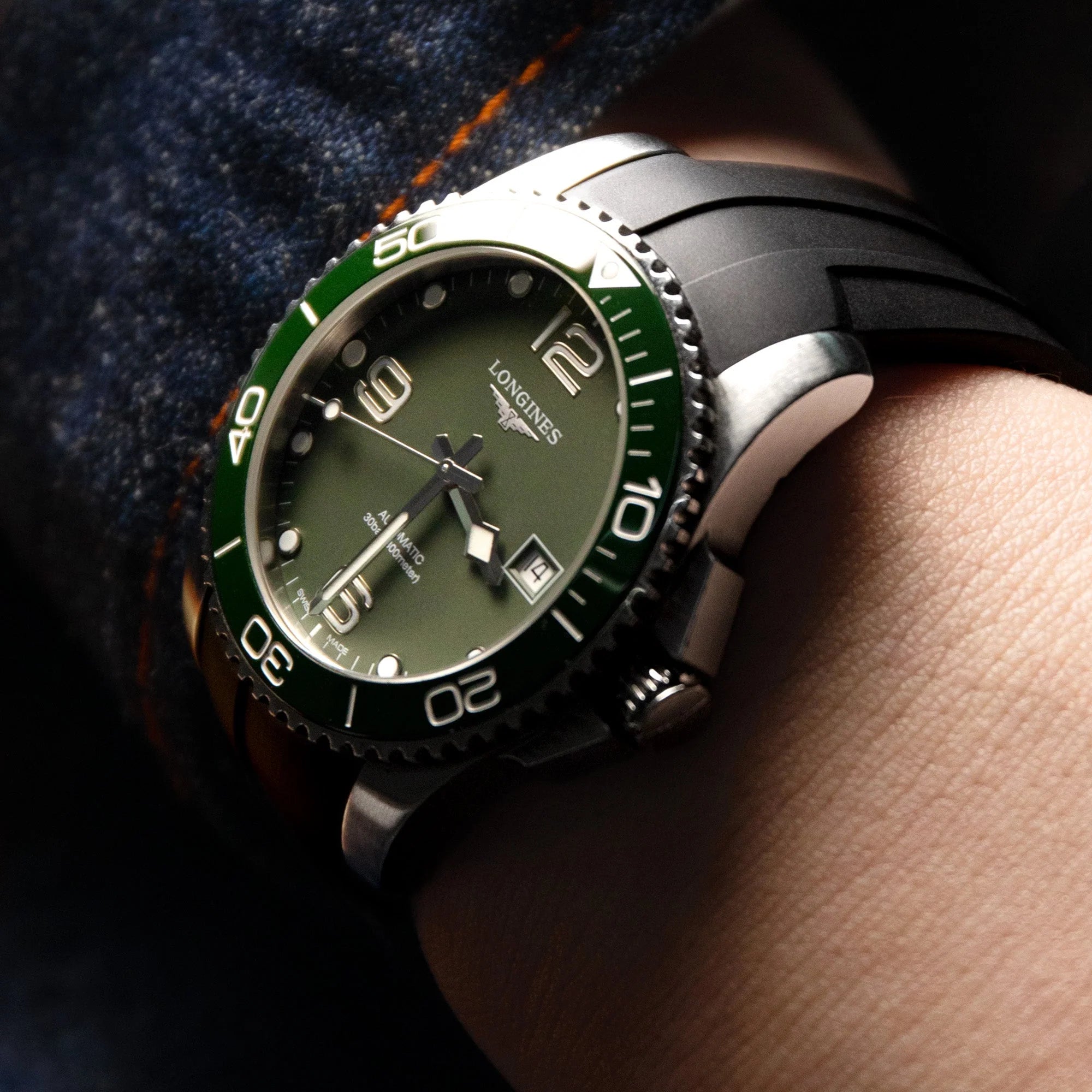 Longines HydroConquest dive watch with green bezel and olive dial on black rubber strap, worn on wrist