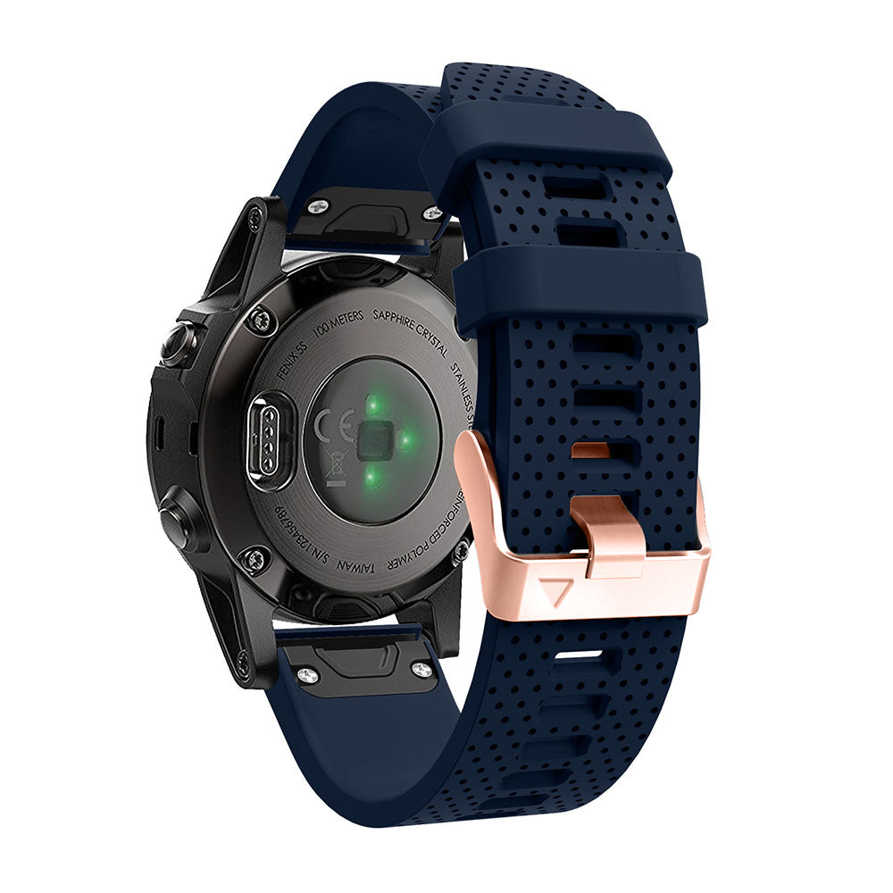Black smartwatch with sapphire crystal face, green LED indicators, and navy perforated silicone band with rose gold QuickFit 20mm hardware clasp