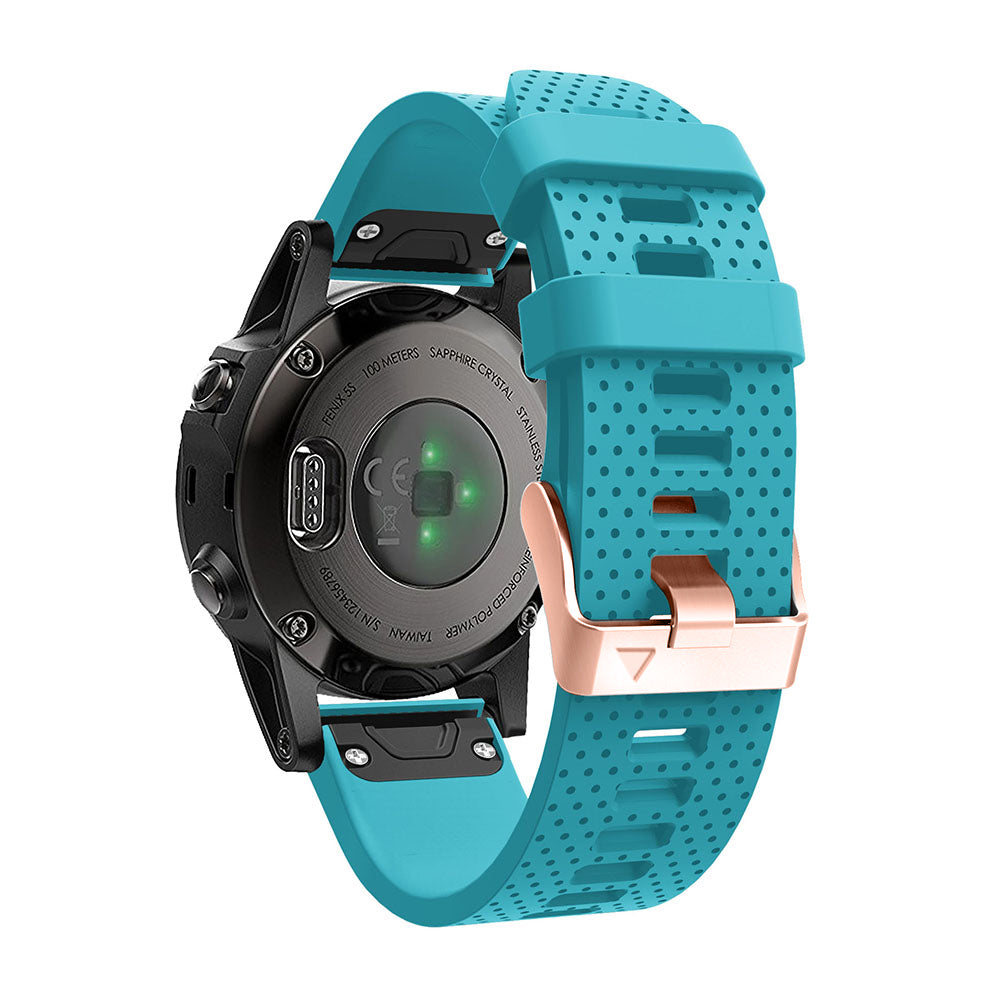 Sports smartwatch with turquoise perforated silicone QuickFit band and rose gold hardware, black digital watch face with green indicators