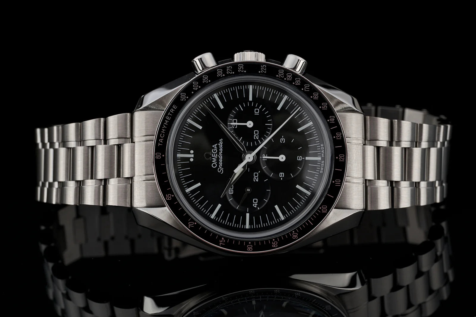 Omega Speedmaster chronograph watch with black dial, stainless steel bracelet and tachymeter bezel on black background