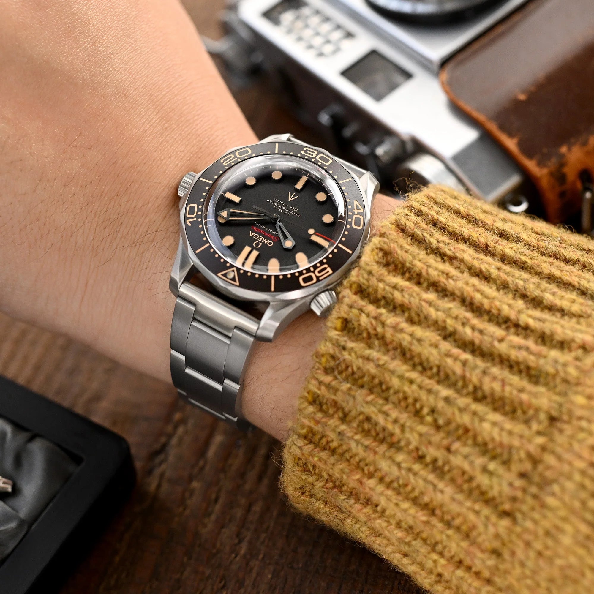 Titanium quick release watch band with straight end lugs on luxury dive watch, stainless steel bracelet closeup on wrist