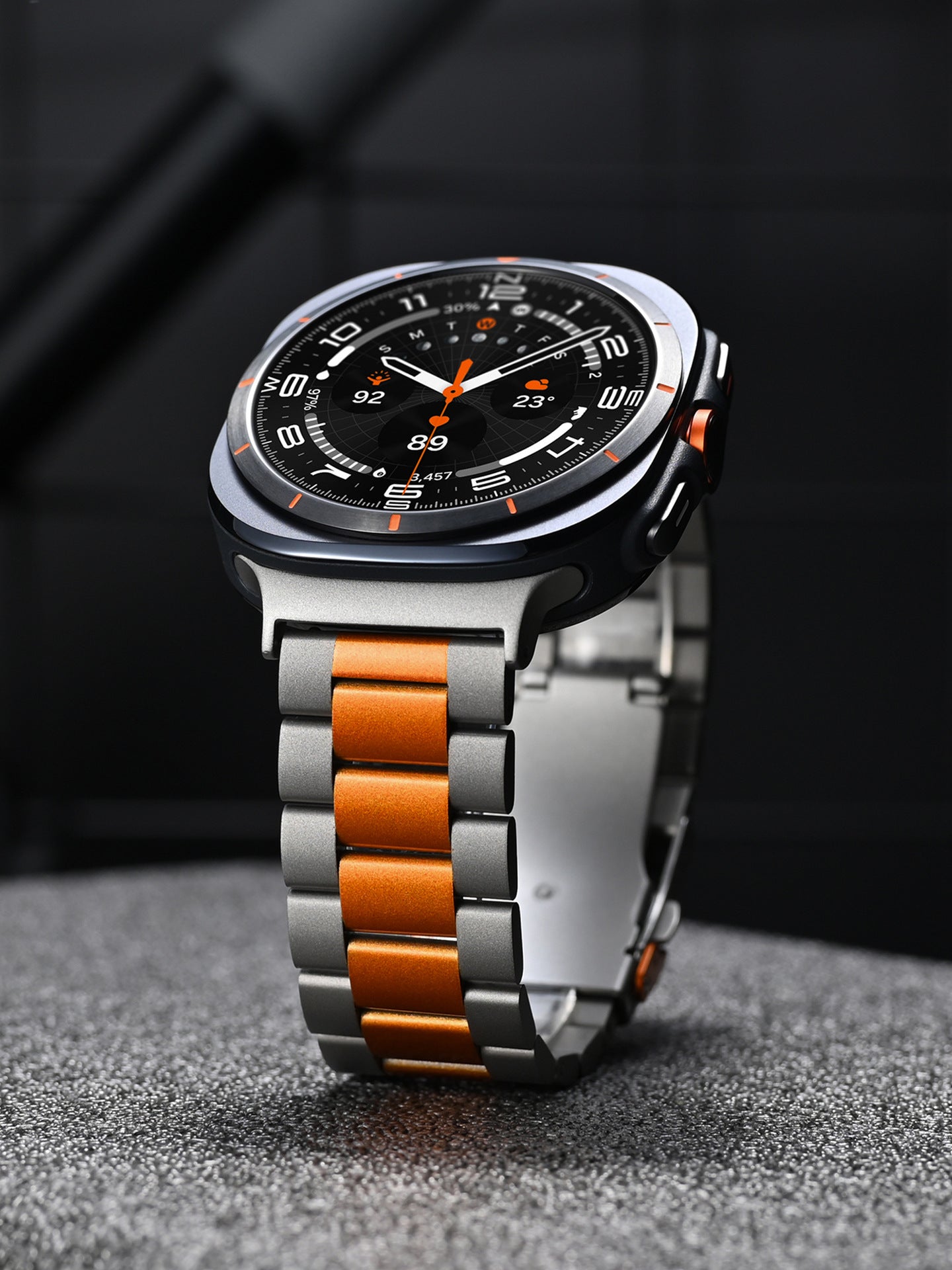 Stainless steel smartwatch with black dial, orange accents, and two-tone silver orange link bracelet