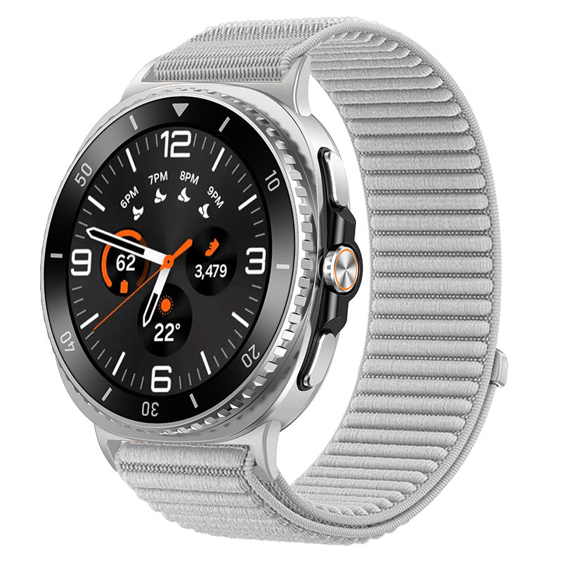 Silver smartwatch with black dial, orange accents, and gray fabric sports loop band showing fitness metrics