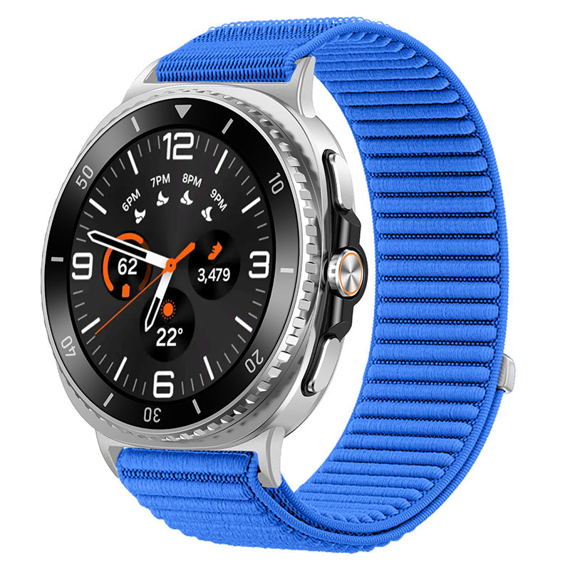 Silver smartwatch with black dial, orange accents, and bright blue sports loop band displaying time and fitness metrics