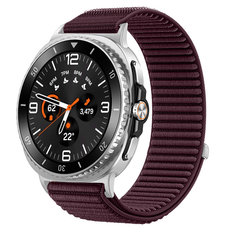 Silver smartwatch with black dial, orange accents, and burgundy sports loop band displaying fitness metrics