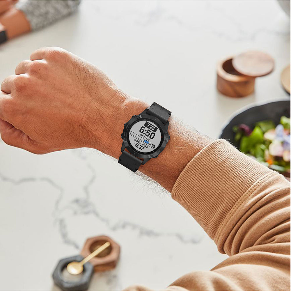 Black digital sports watch with white display on man's wrist, black leather band, casual kitchen setting