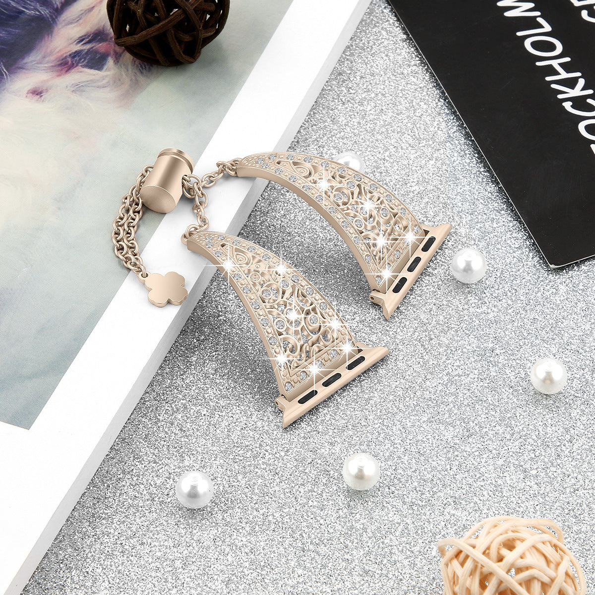 Rose gold filigree Apple Watch band with ornate scrollwork design and matching charm bracelet on marble surface