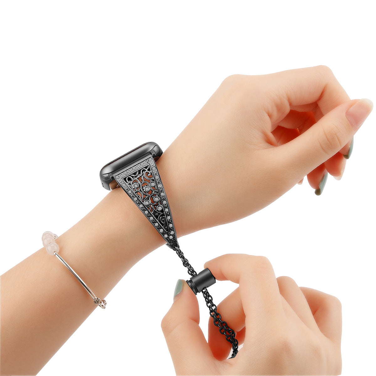 Black ornate Apple Watch bracelet band with decorative filigree pattern and chain attachment worn on wrist