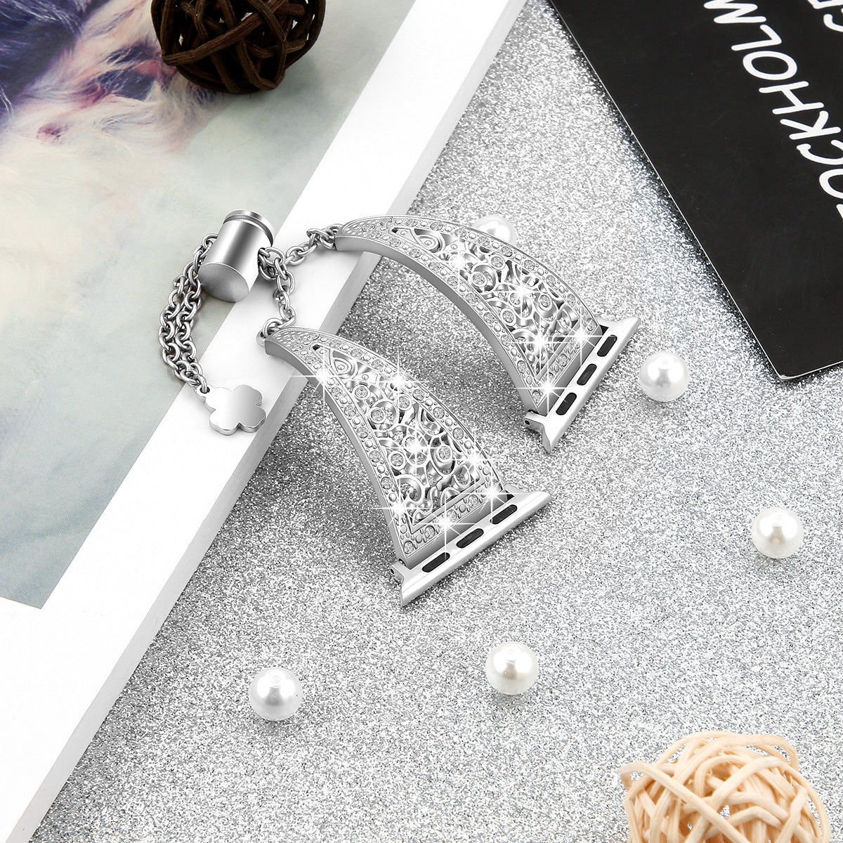 Silver filigree Apple Watch band with ornate geometric pattern design and matching charm bracelet on display with pearls