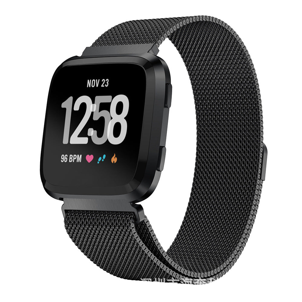 Black Fitbit Versa smartwatch with black Milanese mesh band, displaying time 12:58, date, and health metrics on screen
