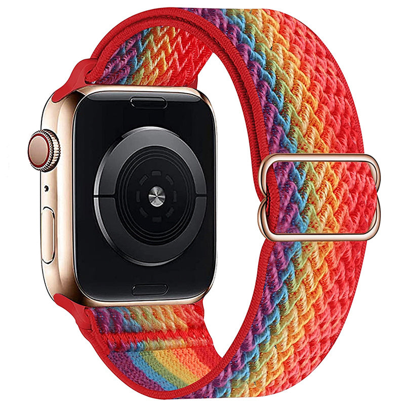 Apple Watch with gold stainless steel case and red woven loop band featuring rainbow stripe pattern