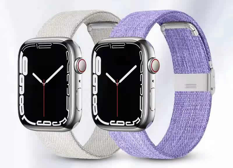 Three Apple Watch Series 7 models with canvas bands in cream, gray, and purple with metal clasps