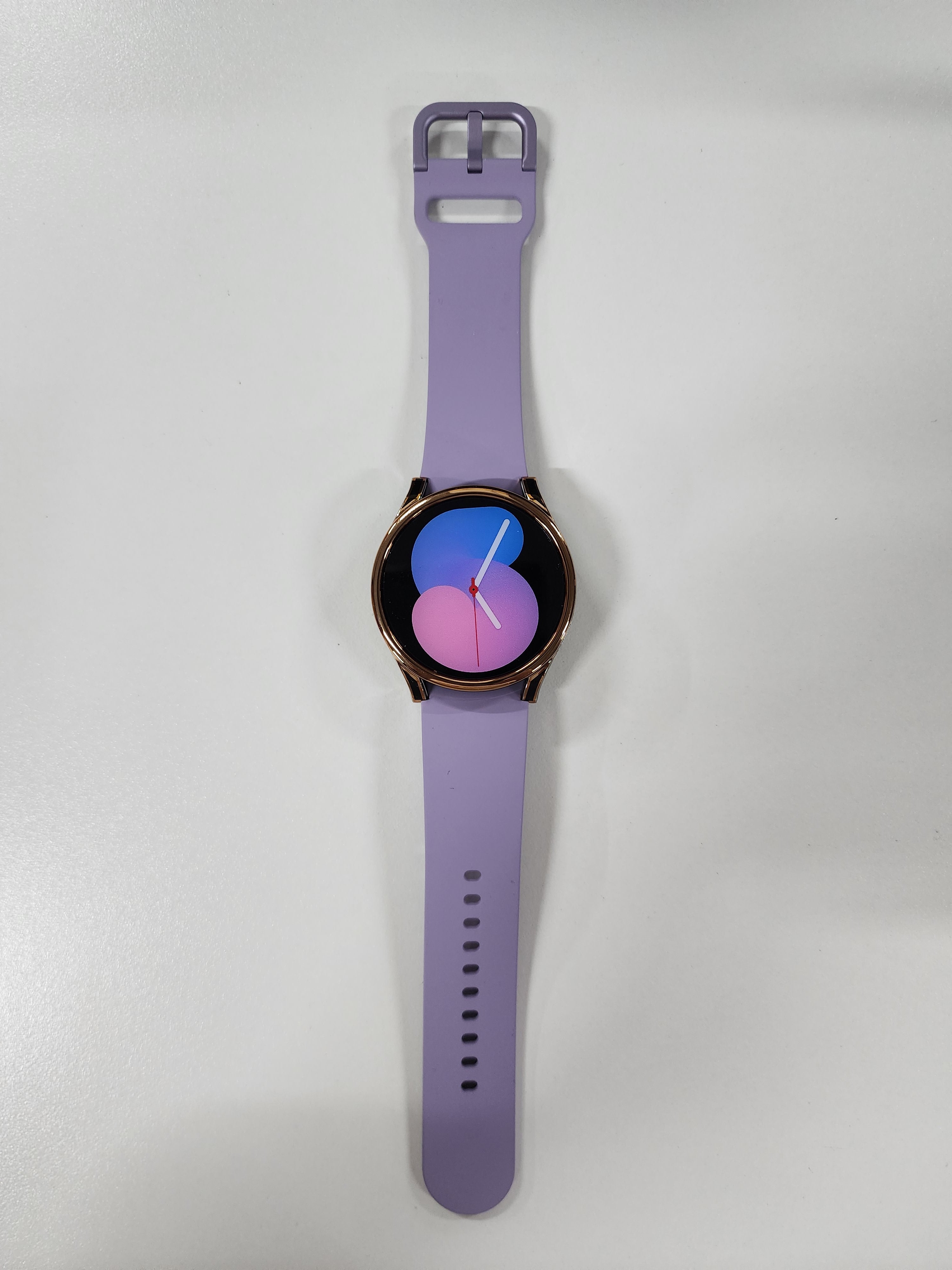 Purple silicone smartwatch band with rose gold case and colorful gradient dial display for Galaxy Watch 4 and 5