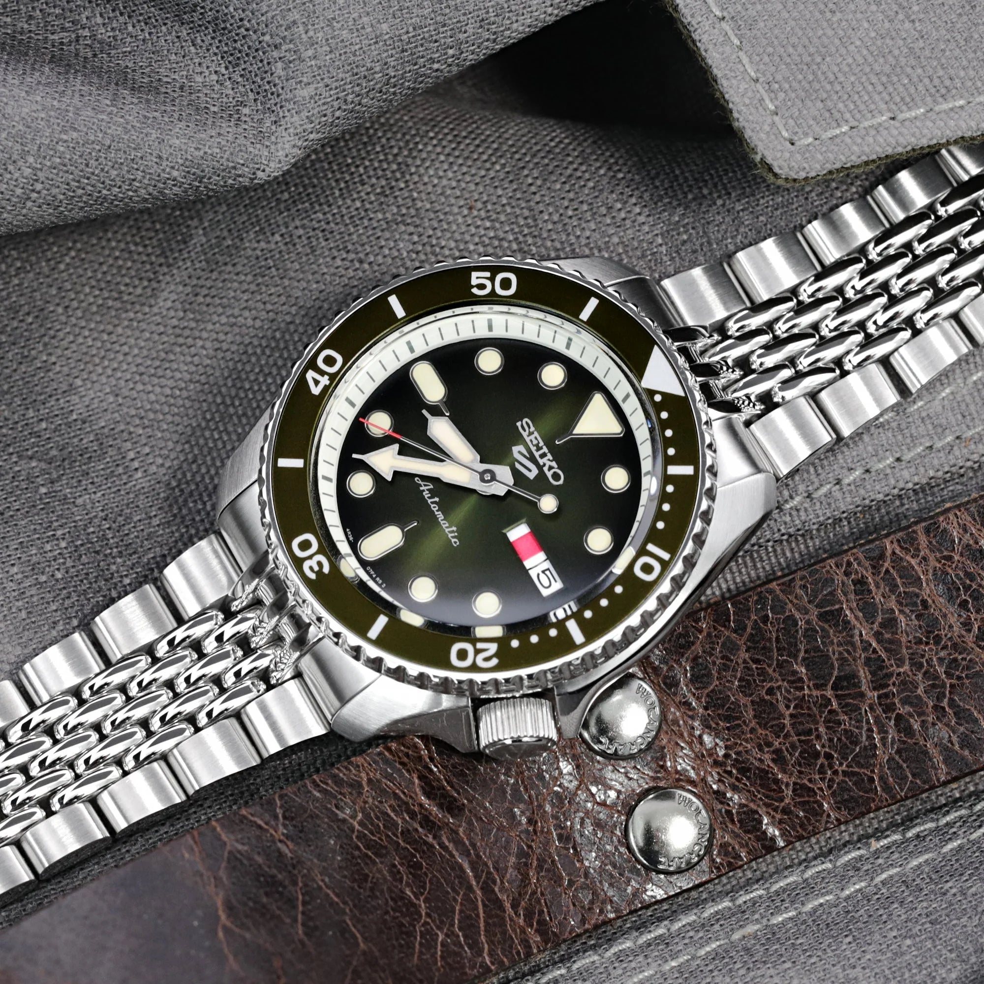 Seiko 5 automatic watch with stainless steel bracelet and black dial on brown leather strap