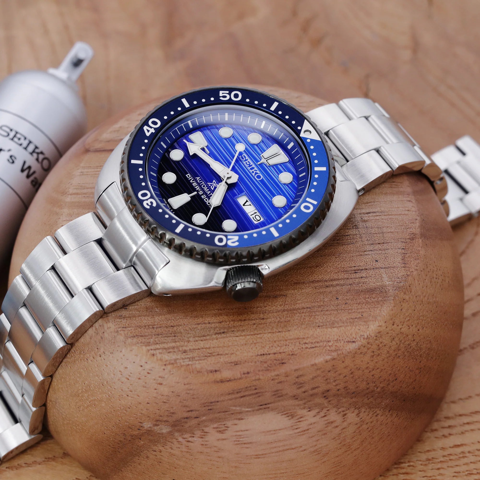 Seiko Prospex Turtle SRP777 dive watch with blue dial and stainless steel Super-O Boyer bracelet on wooden display stand