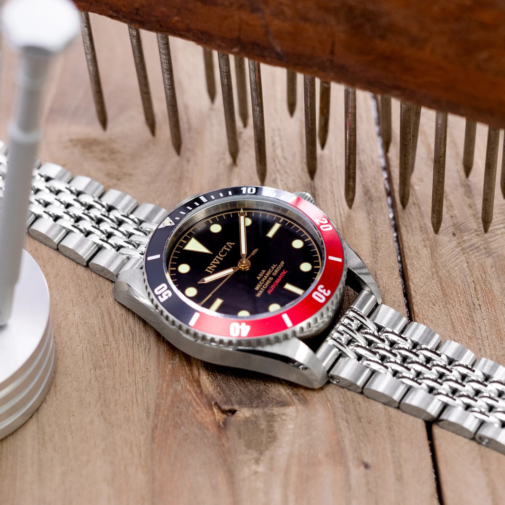 Strapcode Goma BOR stainless steel watch bracelet with V-clasp on wooden surface