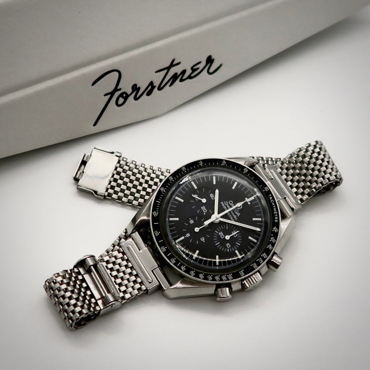 Stainless steel mesh watch bracelet with straight ends and integrated clasp on white background with Forstner branding