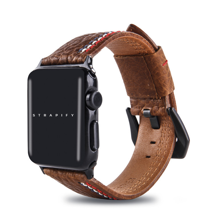 Brown leather Apple Watch band with asymmetrical red and white stitch detail, black hardware connector